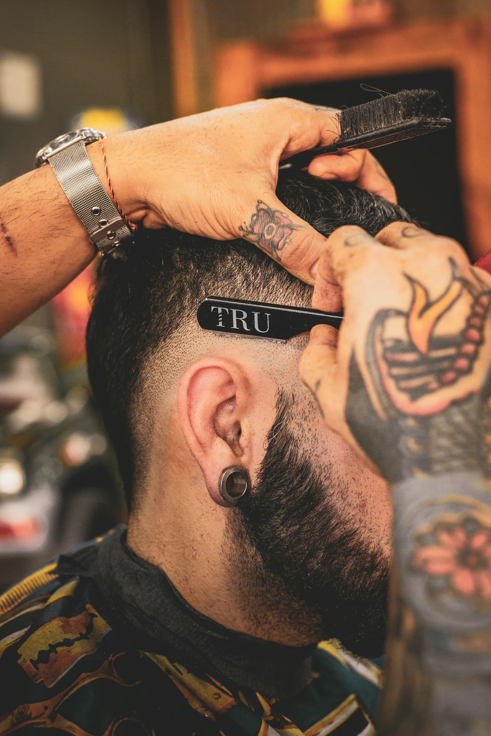 Barber refining a fade with a straight razor