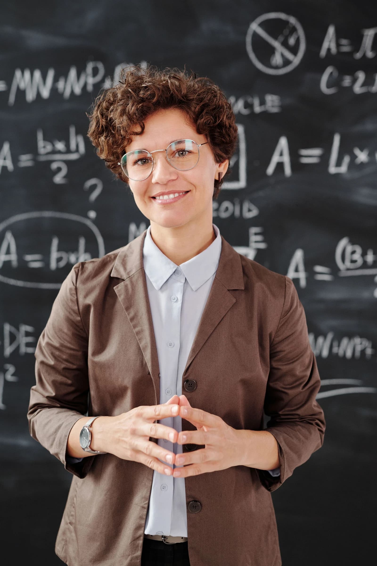 Tutor standing in front of a chalkboard of formulas